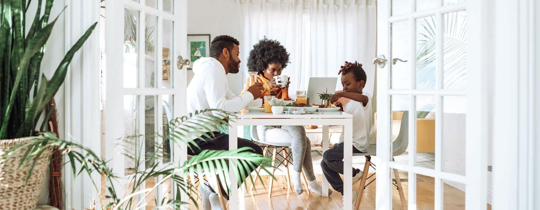 young family of three eat together at the breakfast table