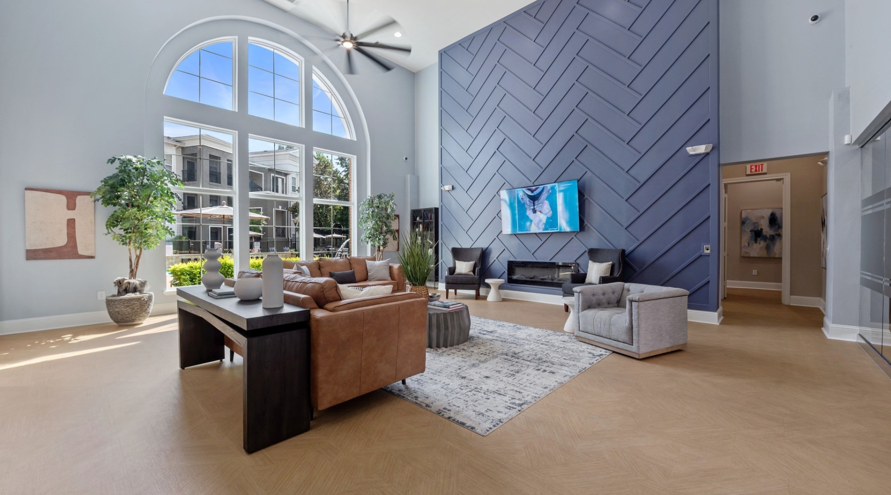 a clubroom with a couch, chairs, tables and a tv